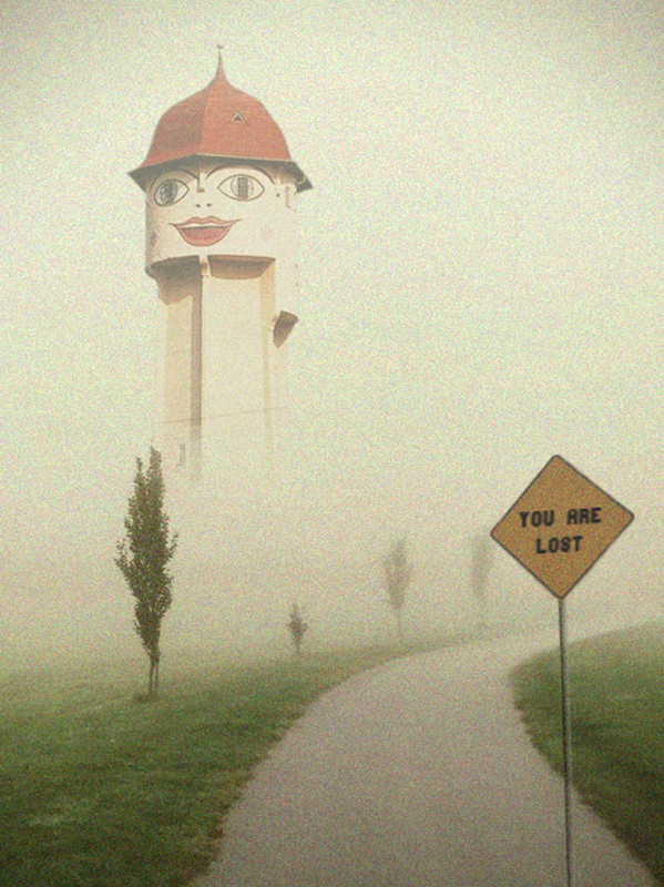 photomontage d'un chemin entouré d'herbe menant à un château d'eau avec un visage et un panneau au premier plan.